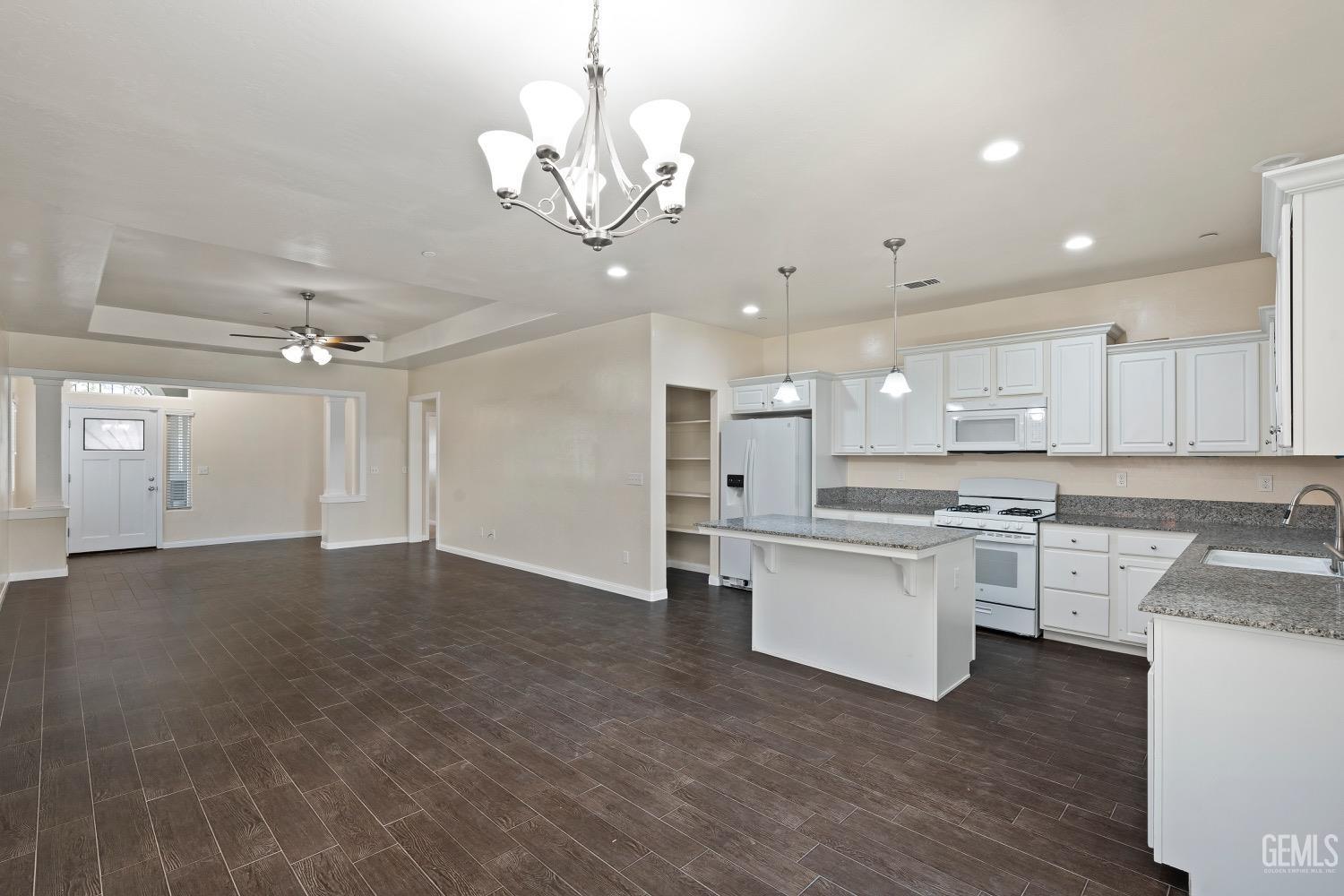 Undisclosed Address Bakersfield, CA 93311 - Photo 7 of 27 a open kitchen with stainless steel appliances granite countertop a sink dishwasher a stove and a refrigerator with wooden floor
