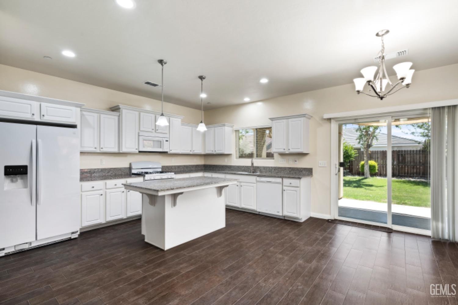 Undisclosed Address Bakersfield, CA 93311 - Photo 8 of 27 a kitchen with stainless steel appliances granite countertop a stove top oven a sink a refrigerator and white cabinets with wooden floor