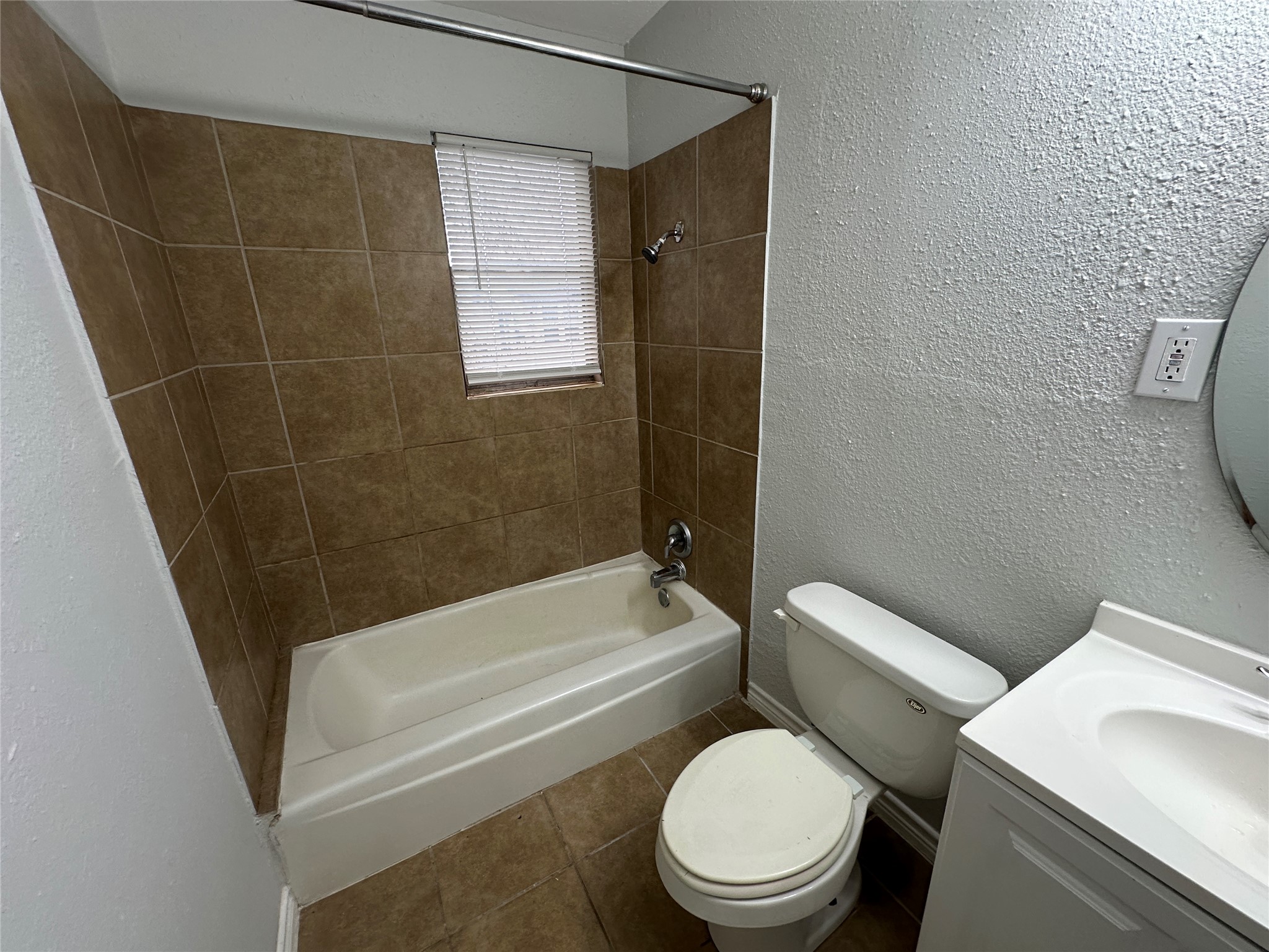 4911 Delano Street, Unit 1 Houston, TX 77004 - Photo 7 of 14 a white toilet and tub sitting next to a bathroom sink