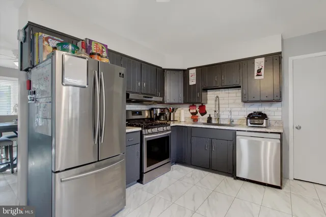 a kitchen with stainless steel appliances granite countertop a stove a refrigerator and a cabinets