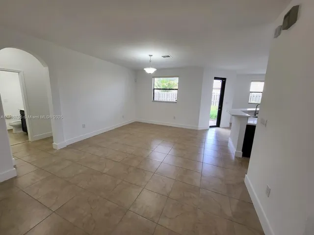 a view of a hallway with wooden floor and a bathroom