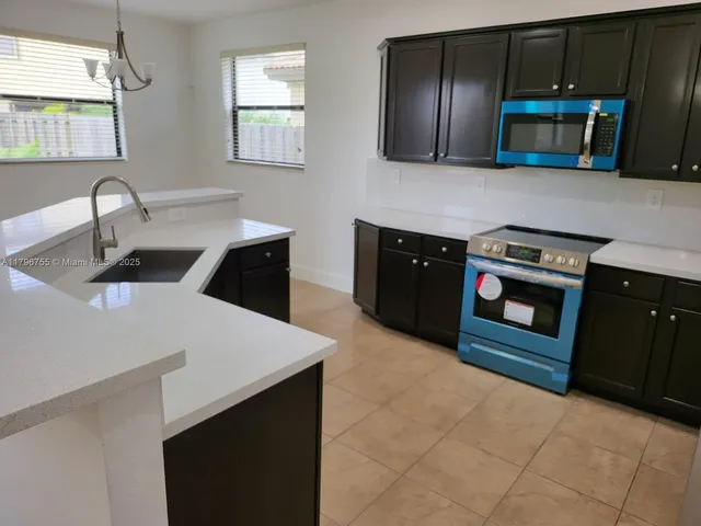 a kitchen with stainless steel appliances a stove a microwave sink and cabinets