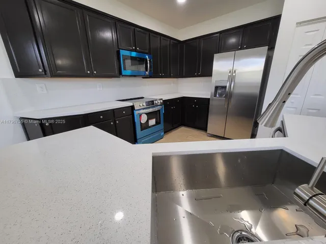 a kitchen with stainless steel appliances a refrigerator a stove a microwave and sink