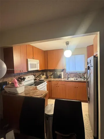 a kitchen with a sink refrigerator and cabinets