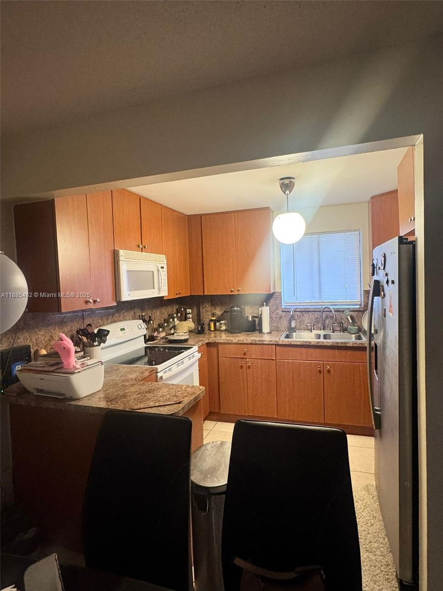 a kitchen with a sink refrigerator and cabinets