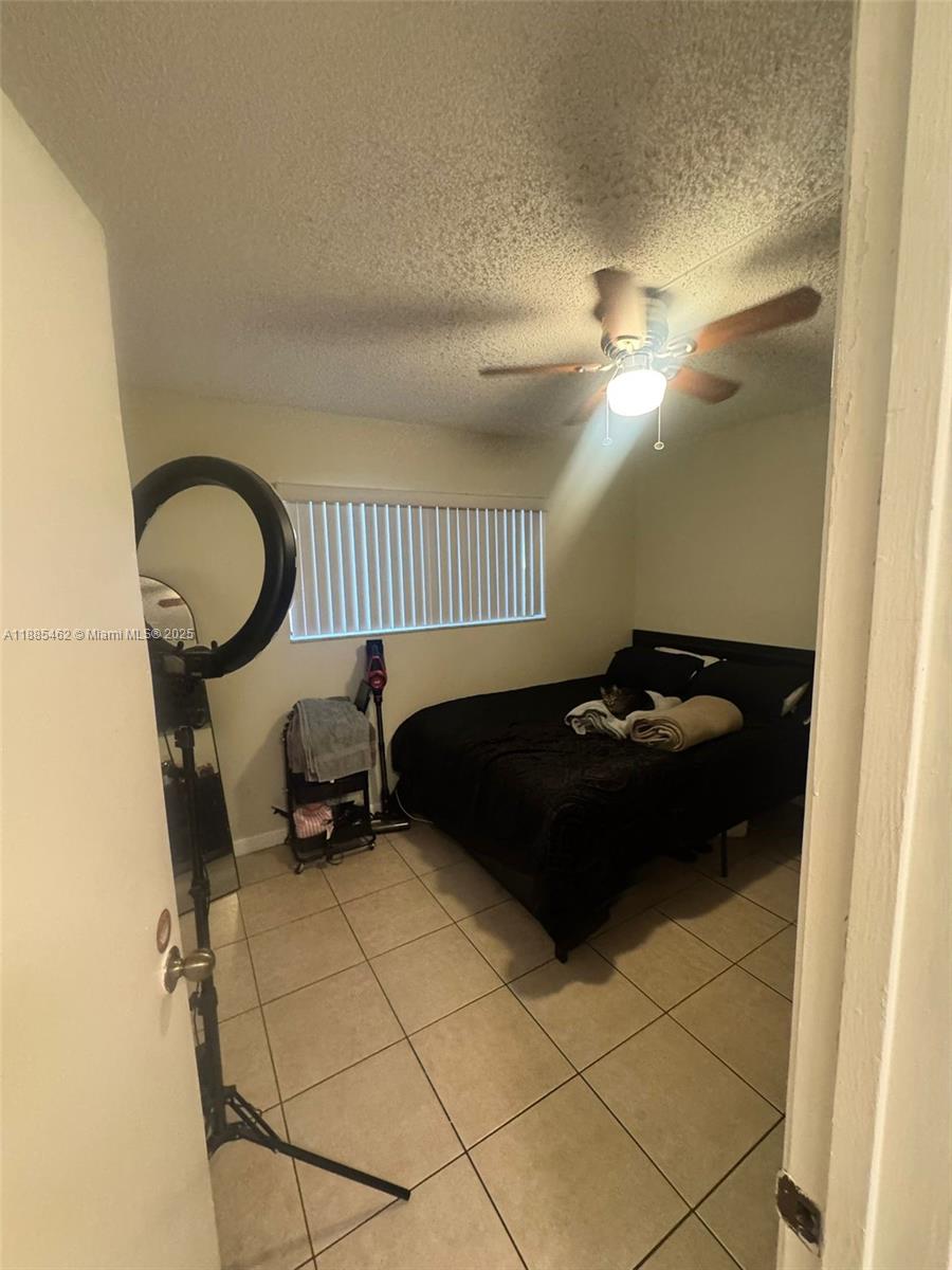 6900 Southwest 39th Street, Unit 106J Davie, FL 33314 - Photo 2 of 9 a bedroom with a bed and a painting on the wall