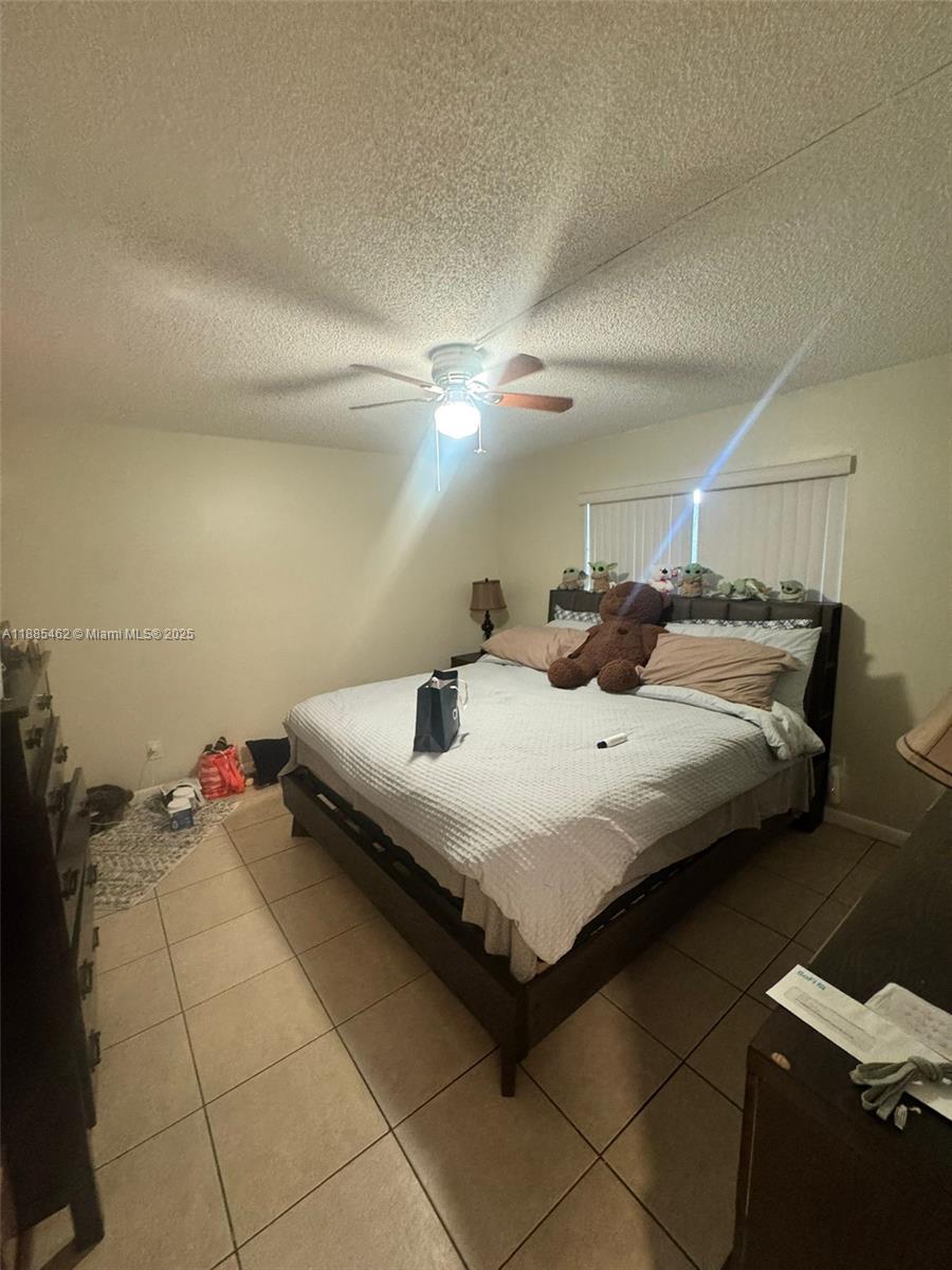 6900 Southwest 39th Street, Unit 106J Davie, FL 33314 - Photo 4 of 9 a bedroom with a bed and a ceiling fan