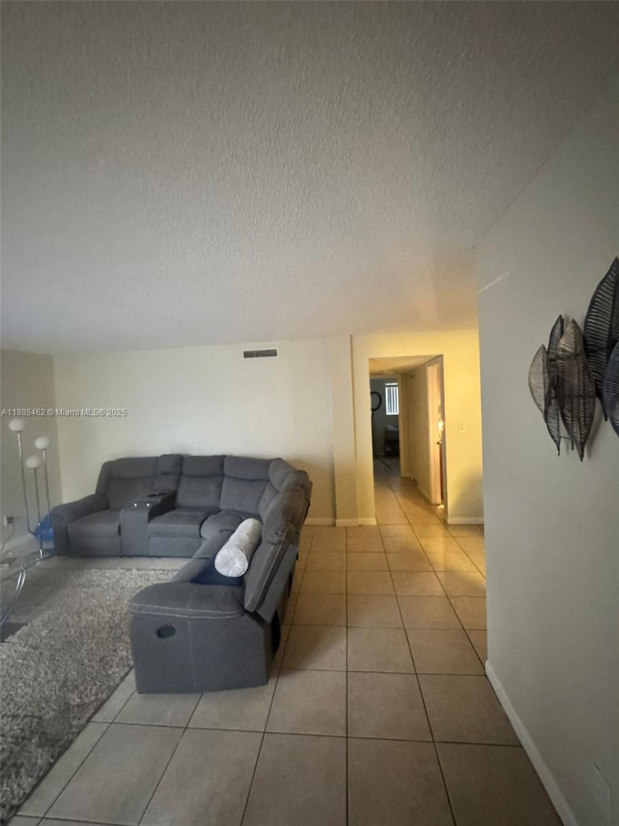 6900 Southwest 39th Street, Unit 106J Davie, FL 33314 - Photo 8 of 9 a living room with furniture and a rug