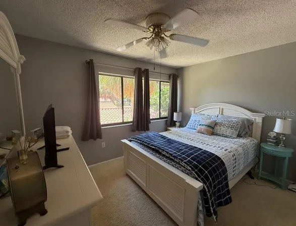 a bedroom with a bed a chandelier and a window