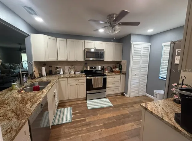 a kitchen with granite countertop a stove and a sink