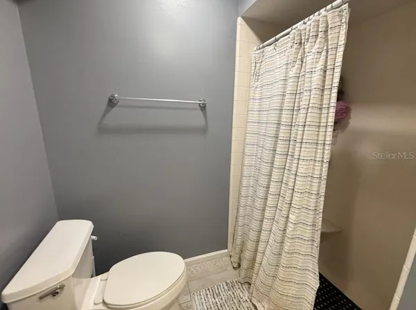 a white toilet sitting next to a shower curtain