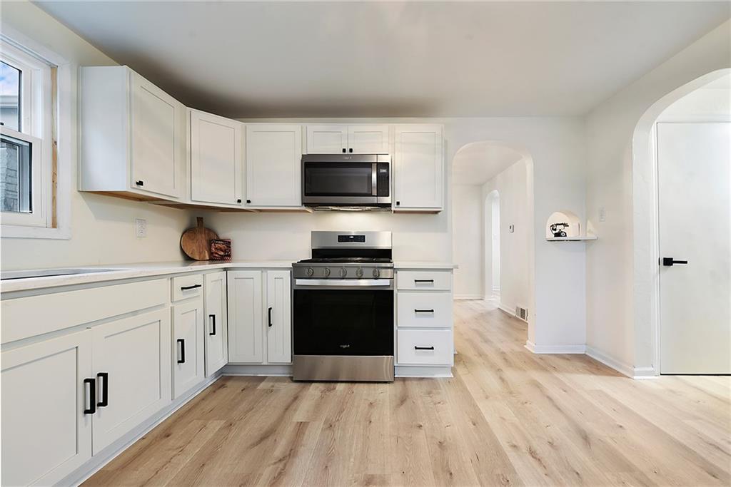 657 Ridge Road Pittsburgh, PA 15205 - Photo 5 of 30 a kitchen with stainless steel appliances a stove top oven a refrigerator a sink and dishwasher with wooden floor
