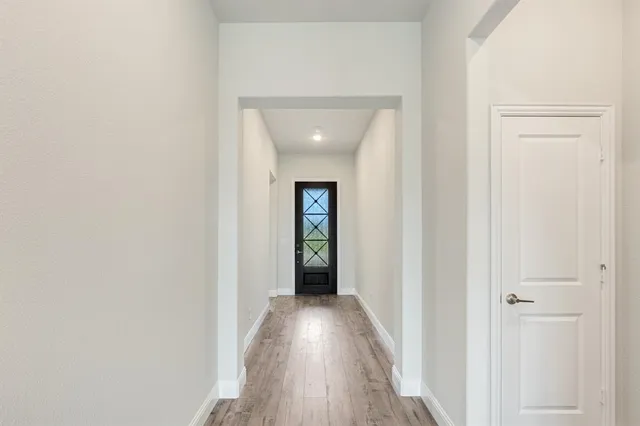 a view of a hallway with wooden floor