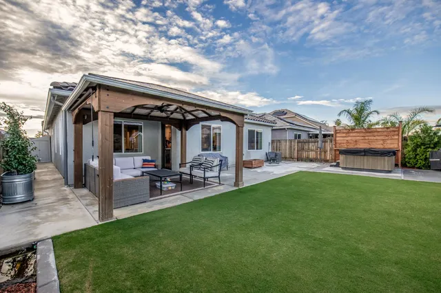 a patio with table and chairs and potted plants