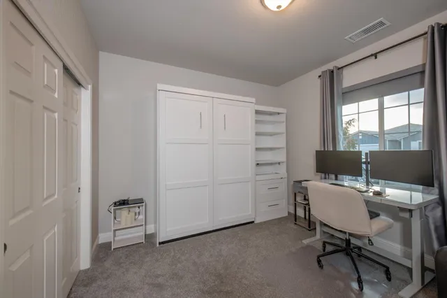 a view of a workspace with furniture and a window