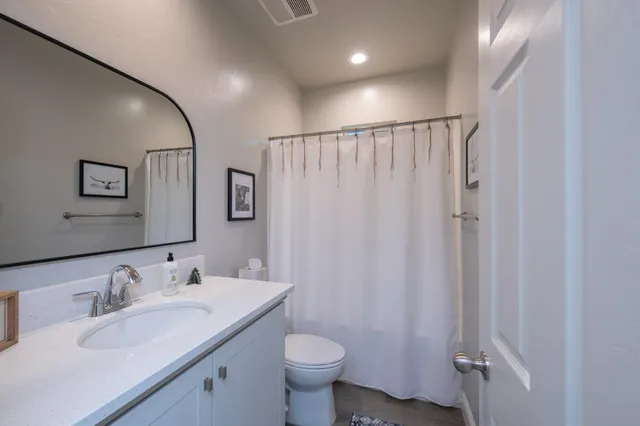 a bathroom with a granite countertop sink toilet and shower
