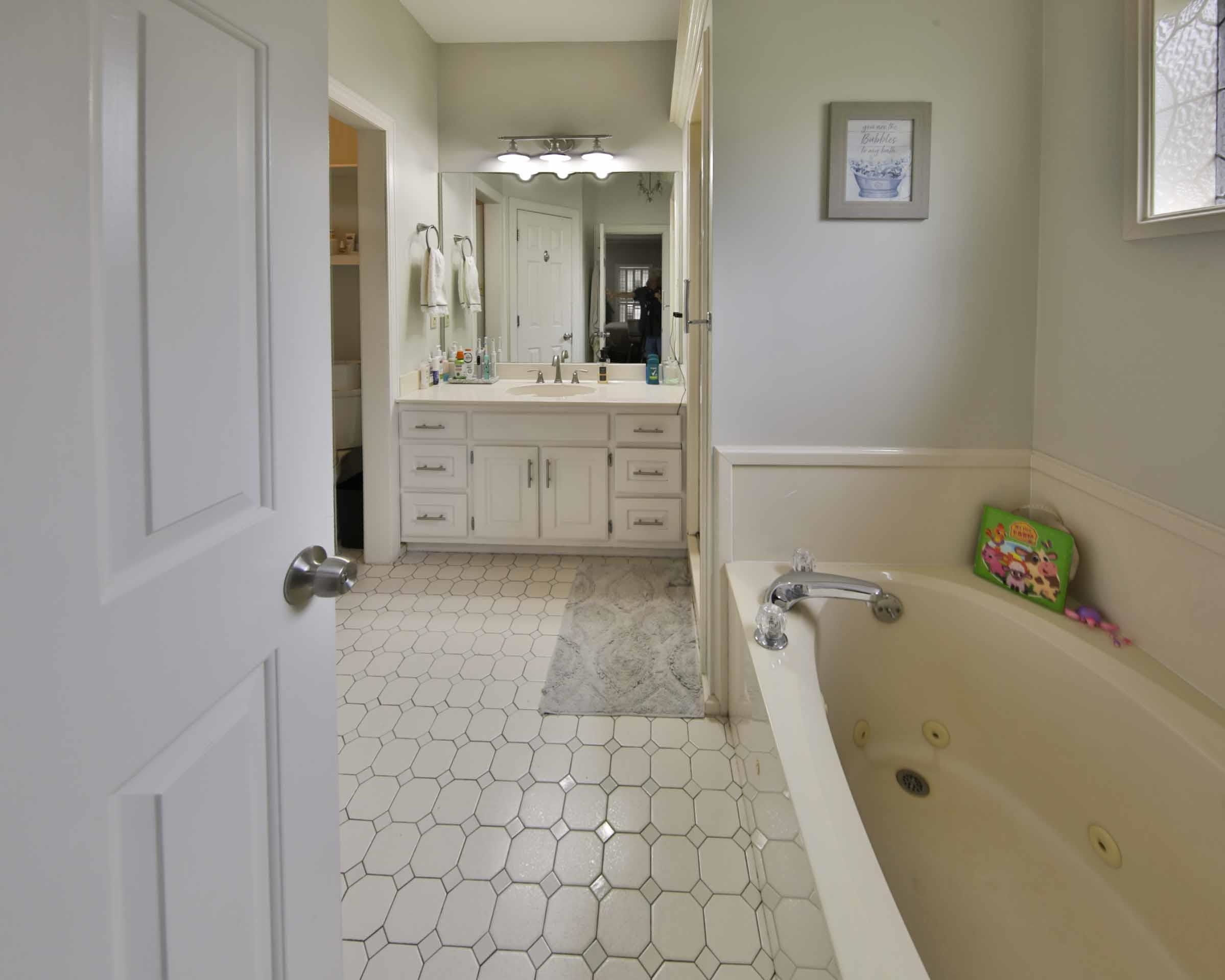 104 Miller Road Covington, TN 38019 - Photo 19 of 25 Bathroom featuring a jetted bathtub, white wainscoting, and a white vanity with a large mirror