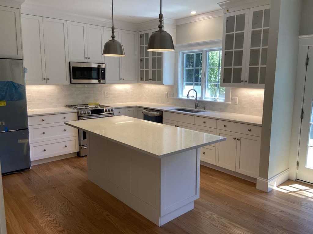 3 Wellesley Avenue, Unit 3 Needham, MA 02494 - Photo 6 of 19 a kitchen with stainless steel appliances granite countertop a sink a stove and a wooden floors