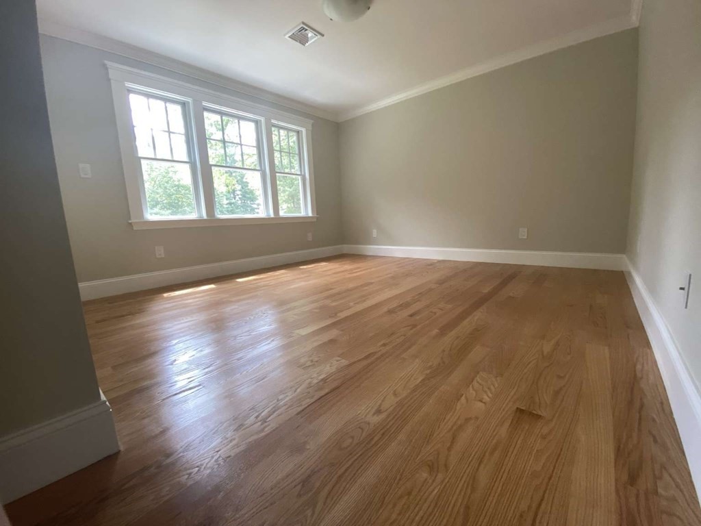 3 Wellesley Avenue, Unit 3 Needham, MA 02494 - Photo 9 of 19 an empty room with wooden floor and windows