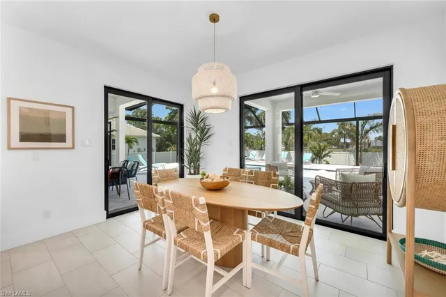 a dining room with furniture large windows and a chandelier