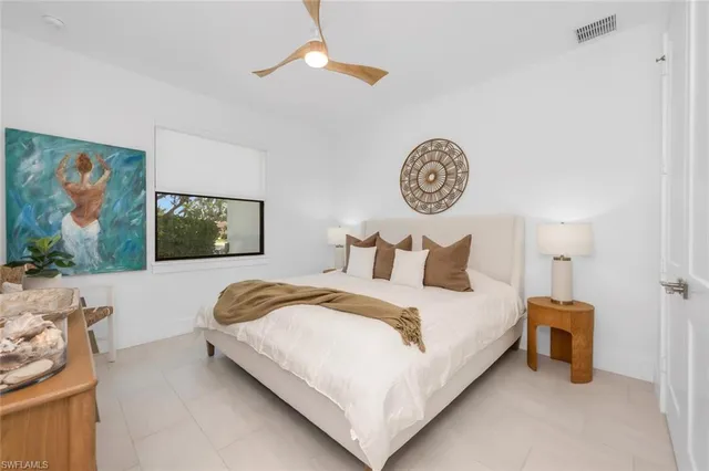 a bedroom with a large bed and a potted plant