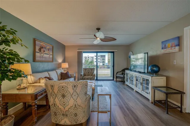 a living room with furniture a chandelier and a flat screen tv