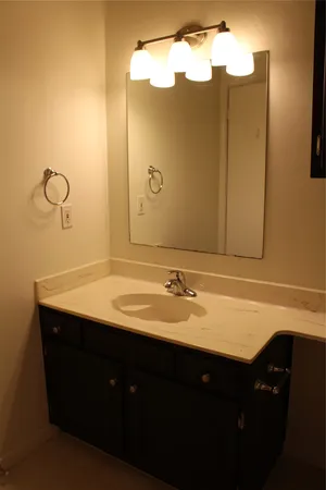 an empty room with wooden floor and fan