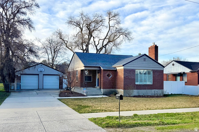 1944 Spring Lane Salt Lake City, UT 84117 - Photo 1 of 1 Ranch-style house featuring an outbuilding, a detached garage, a chimney, brick siding, and a shingled roof