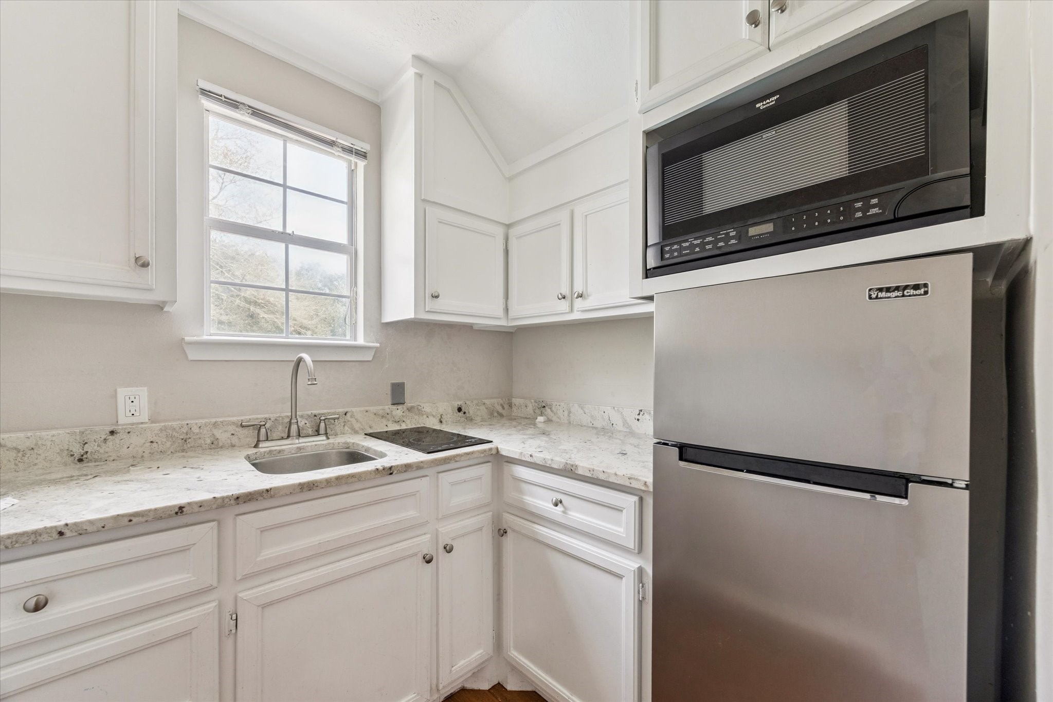 3577 Katy Hockley Road Katy, TX 77493 - Photo 36 of 50 Convenient kitchenette with granite counters, stainless refrigerator, cooktop, and built-in microwave, ideal for guests or extended stays.