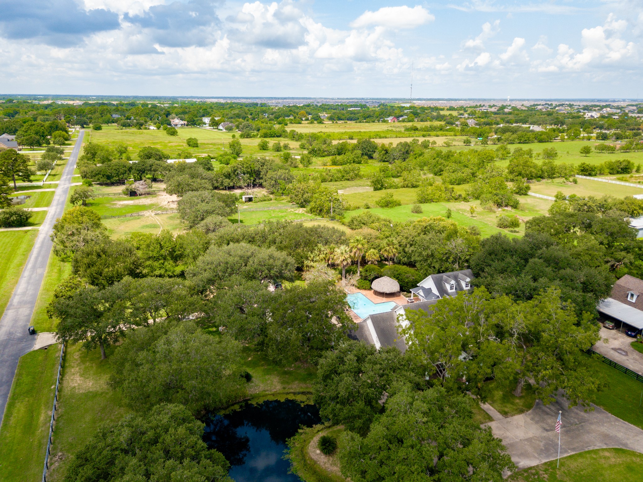 3577 Katy Hockley Road Katy, TX 77493 - Photo 47 of 50 From above, the home reveals its retreat-like setting, surrounded by mature trees, a sparkling pool, and open land stretching into the horizon, perfect for entertaining or peaceful escapes.
