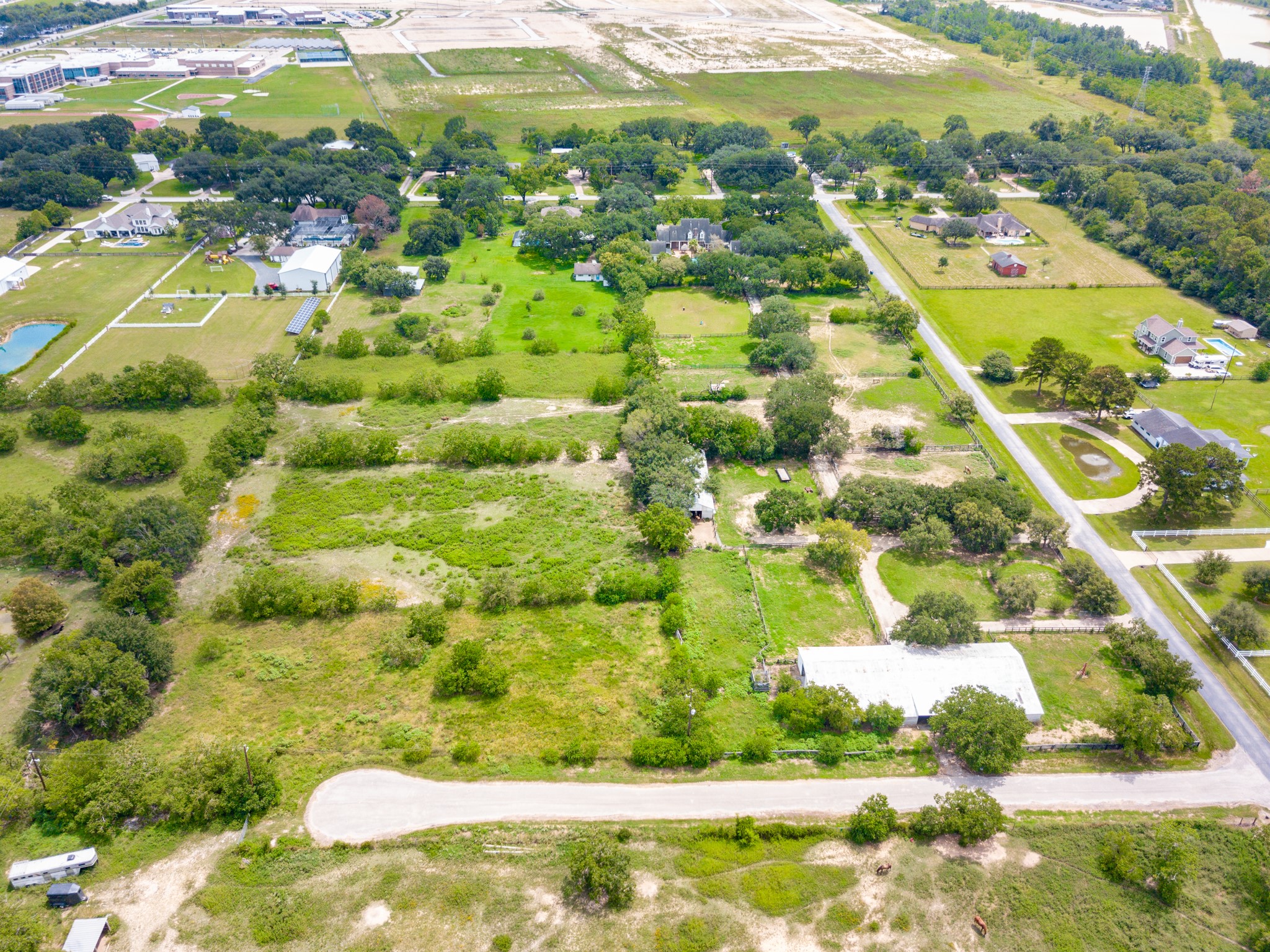3577 Katy Hockley Road Katy, TX 77493 - Photo 50 of 50 This aerial perspective captures the estate in its entirety—20+ acres of serene countryside featuring a timeless home, resort-style pool, private pond, barns, and equestrian-ready pastures. A rare sanctuary where luxury living meets wide-open possibilities.