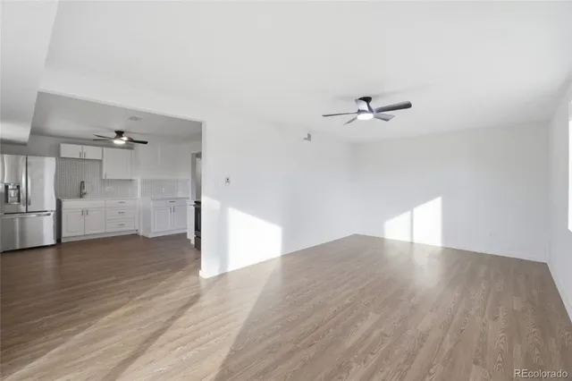 a view of a kitchen with wooden floor and a ceiling fan