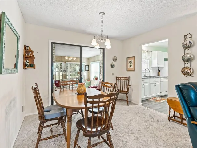 a living room with furniture kitchen view and a chandelier