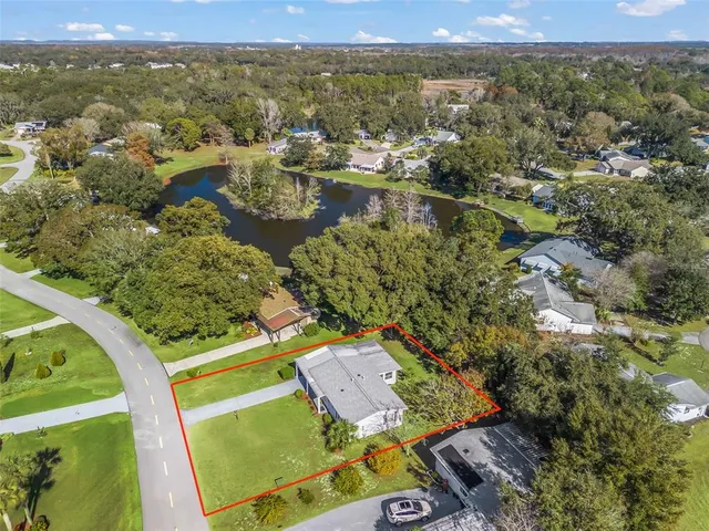 an aerial view of residential houses with outdoor space and trees