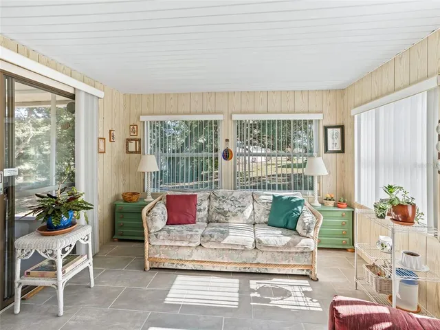 a living room with furniture and a floor to ceiling window