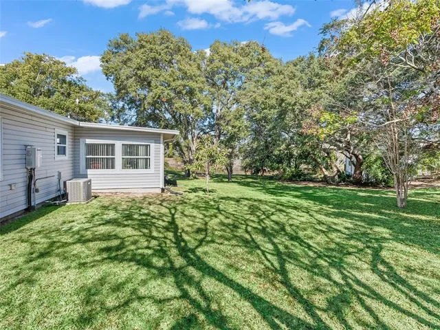 a living room with lots of white furniture and a dining table with chair