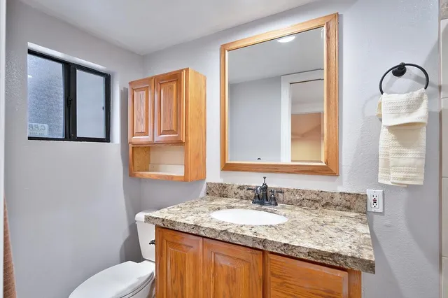 a bathroom with a granite countertop sink and a mirror