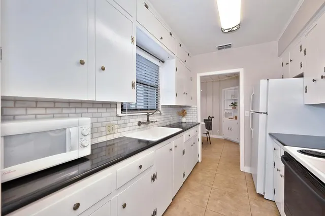 a kitchen with granite countertop cabinets stainless steel appliances a sink and a counter top space