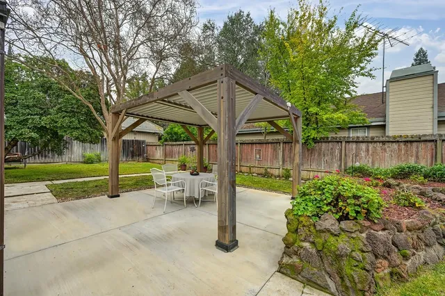 a view of a house with backyard and sitting area