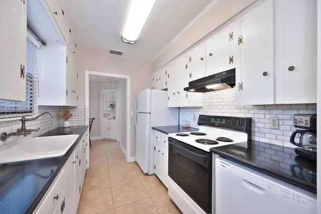 a kitchen with stainless steel appliances granite countertop a sink a stove and a refrigerator