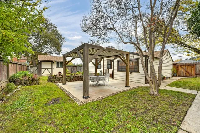 a view of a house with backyard and a tree