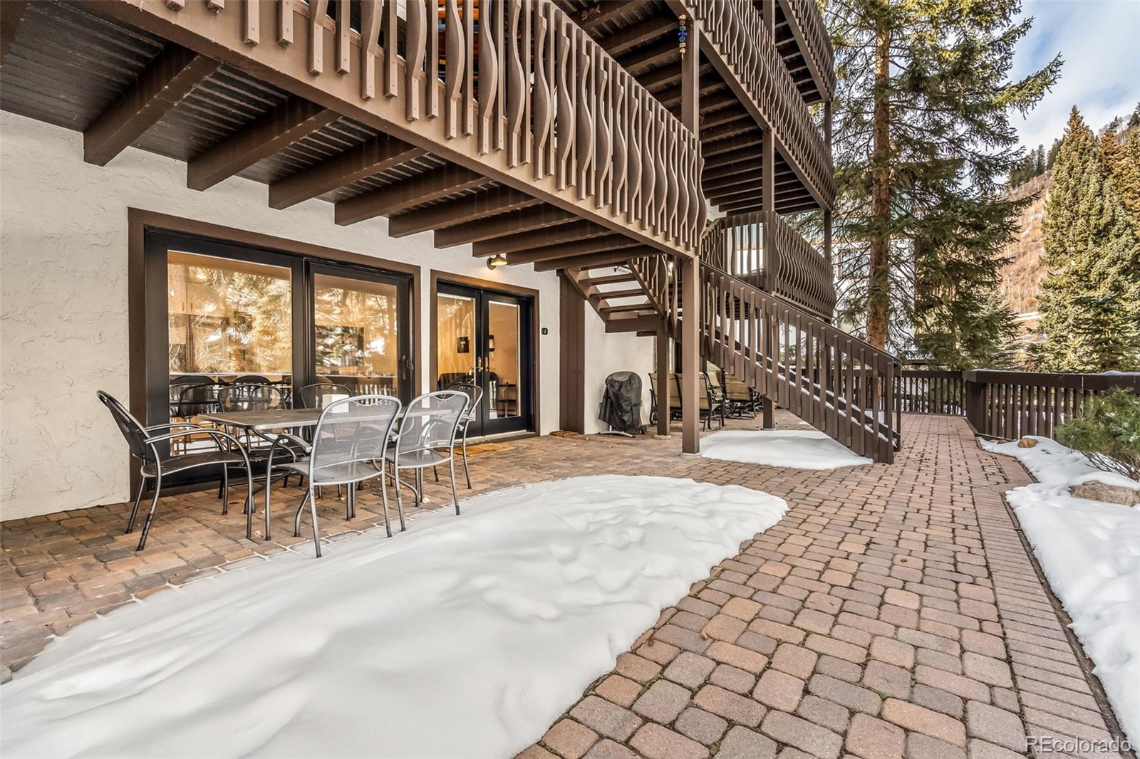4660 Vail Racquet Club Drive, Unit 2 Vail, CO 81657 - Photo 11 of 15 a view of a patio with table and chairs with wooden floor and fence