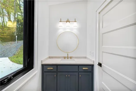 a bathroom with a double vanity sink mirror and bathtub
