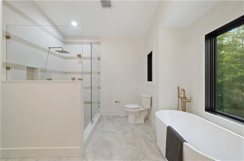 a bathroom with a toilet a sink and mirror