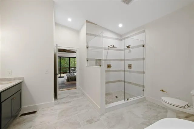 a bathroom with a granite countertop sink a toilet and shower