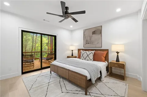 a view of a house with a yard plants and large tree