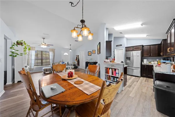 a view of a dining room with furniture a chandelier and wooden floor