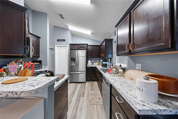 a kitchen with granite countertop stainless steel appliances and wooden cabinets