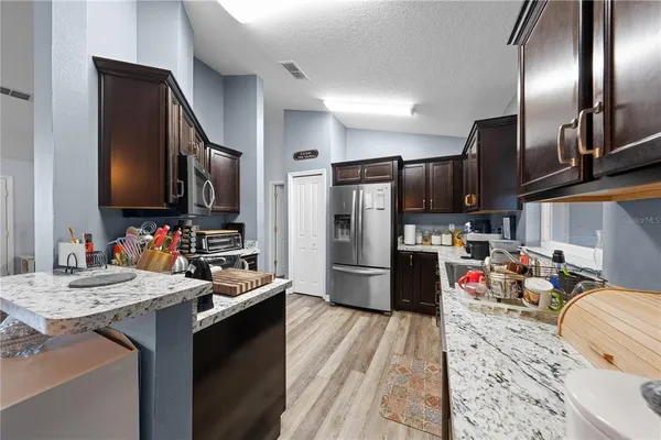a kitchen with granite countertop a refrigerator and a sink