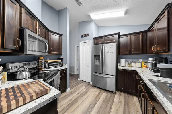 a kitchen with stainless steel appliances granite countertop a refrigerator stove and sink